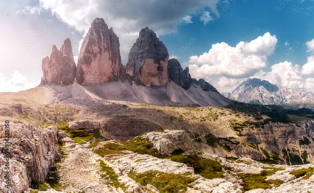 Great sunny view of the National Park Tre Cime di Lavaredo, Panoramic view of three spectacular mountain peaks. Awecome nature landscape. Amazing mountain valley under sunlight. Dolomites Alps