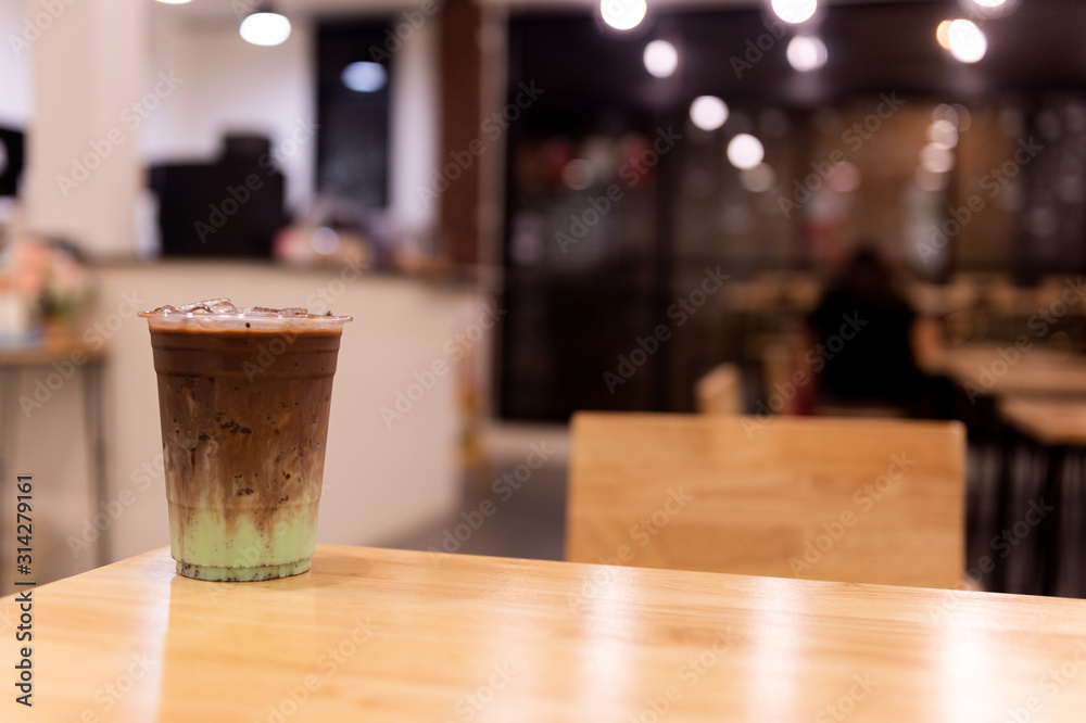 iced mint chocolate drink in plastic glass, put on a wooden table