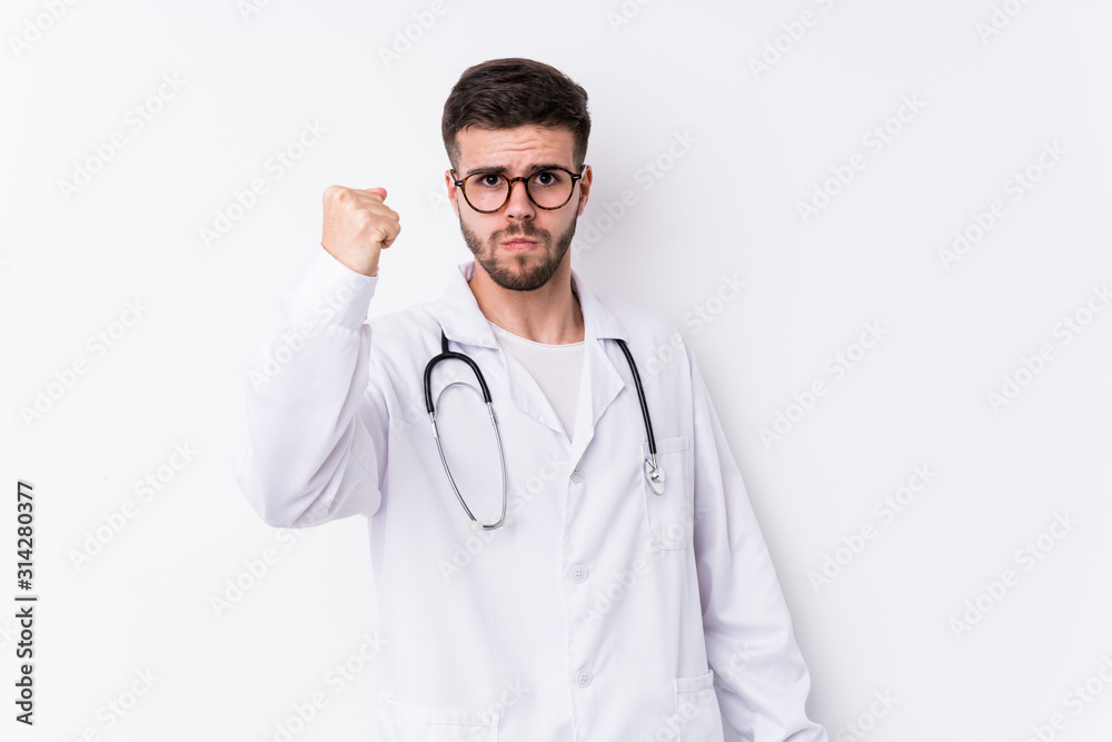 Young caucasian doctor man isolated showing fist to camera, aggressive facial expression. Young caucasian doctor man isolated showing fist to camera, aggressive facial expression.