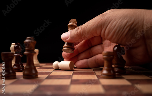 Close up of hands confident businessman moving chess figure in competition success play. the chess game is development analysis, strategy, and plan, the management or leadership concept.