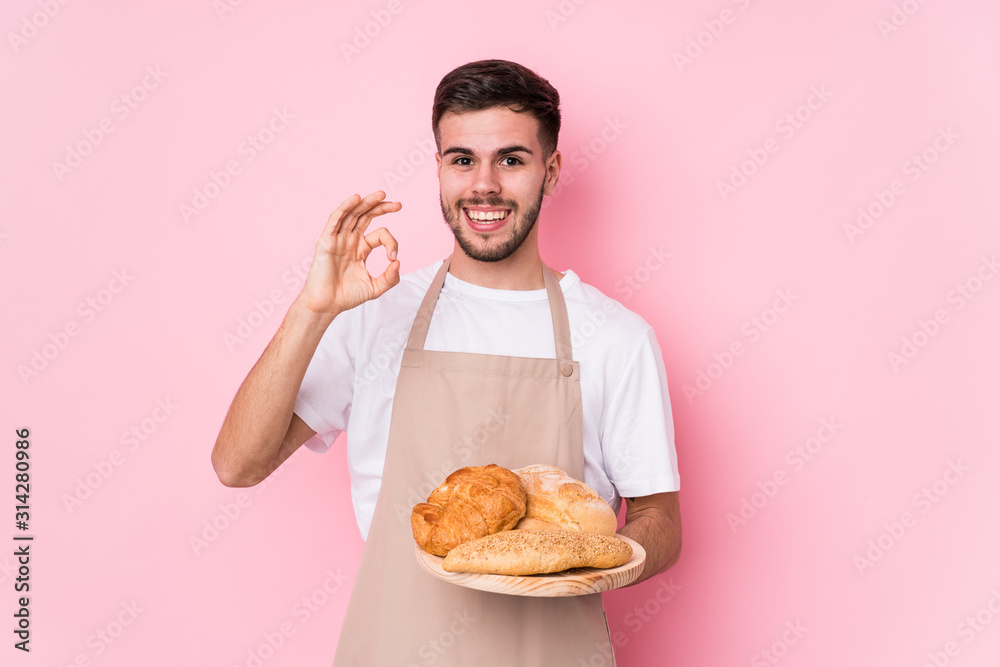 Young caucasian baker man isolated cheerful and confident showing ok gesture. Young caucasian baker man isolated cheerful and confident showing ok gesture.