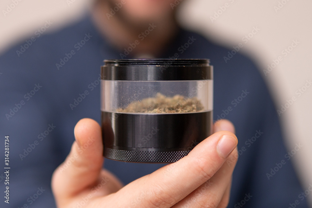 Man preparing and rolling marijuana cannabis joint. Man rolling a