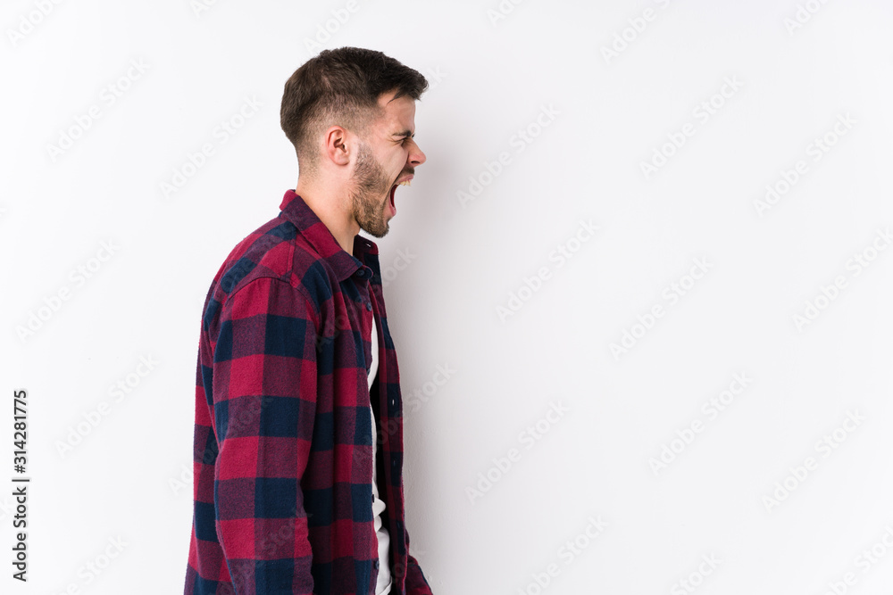 Young caucasian man posing in a white background isolated shouting towards a copy space Young caucasian man posing in a white background isolated shouting towards a copy space