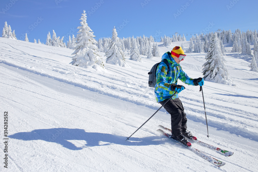 Active Skier skiing downhill on ski piste in mountains Active Skier skiing downhill on ski piste in mountains