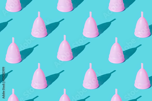 Pink menstrual cup on a green background. Set. Texture photo