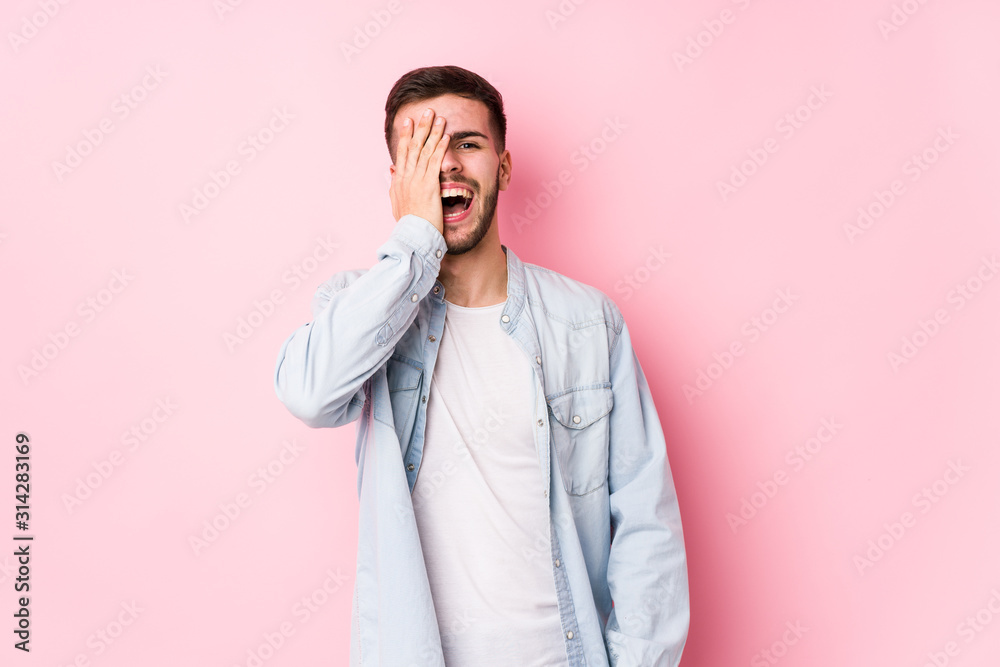 Young caucasian business man posing in a white background isolated having fun covering half of face with palm.< mixto > Young caucasian business man posing in a white background isolated having fun covering half of face with palm.< mixto >