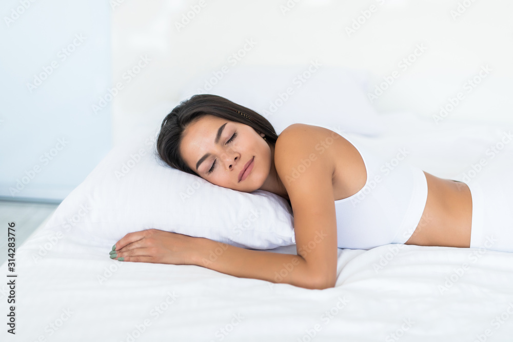 Young pretty woman sleeping on pillow lying in bed at home Young pretty woman sleeping on pillow lying in bed at home