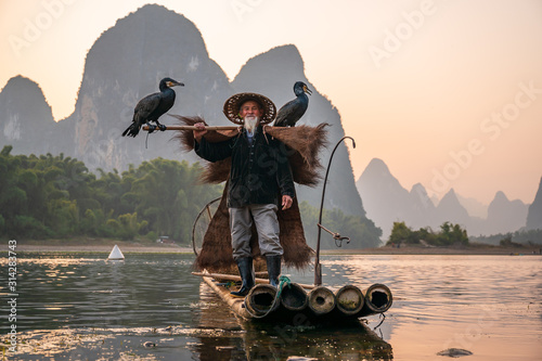 Canvas Print A fisherman and his cormorants on a raft in sunset