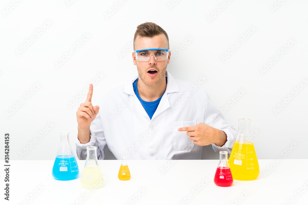 Young scientific with lots of laboratory flask with surprise facial expression Young scientific with lots of laboratory flask with surprise facial expression