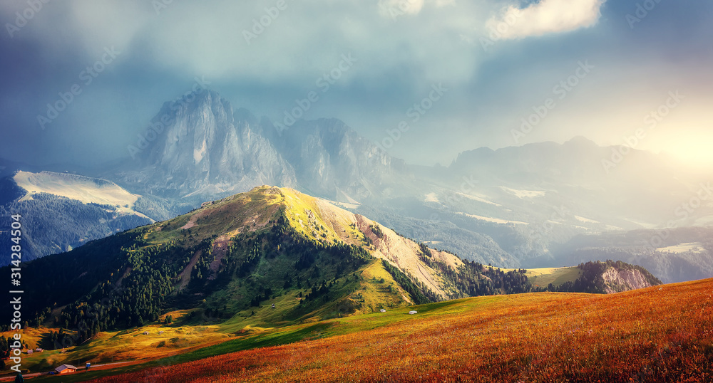 Fantastic sunset in the mountains. Great view of famous Sassolungo peak with overcast Dramatic sky. Wonderful Vall Gardena under sunlight. Majestic Dolomites Mountains. Amazing nature Landscape