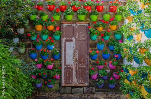 Puerta en madera en Jardín, Antioquia, rodeada de materas multicolores photo