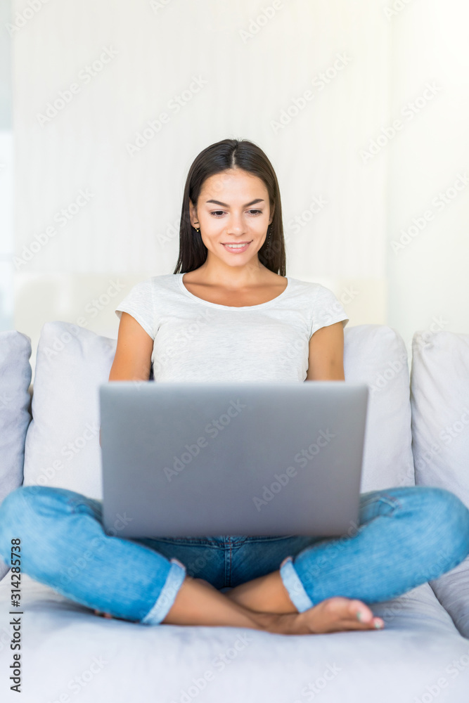 Smiling happy woman sitting on the sofa and using laptop. Smiling happy woman sitting on the sofa and using laptop.