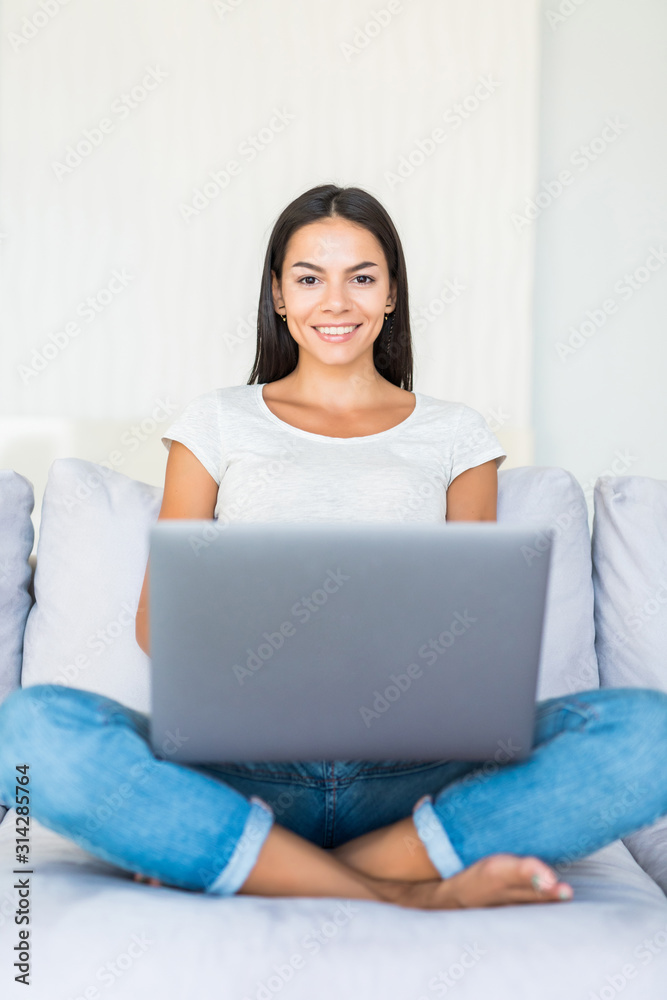 Smiling happy woman sitting on the sofa and using laptop. Smiling happy woman sitting on the sofa and using laptop.