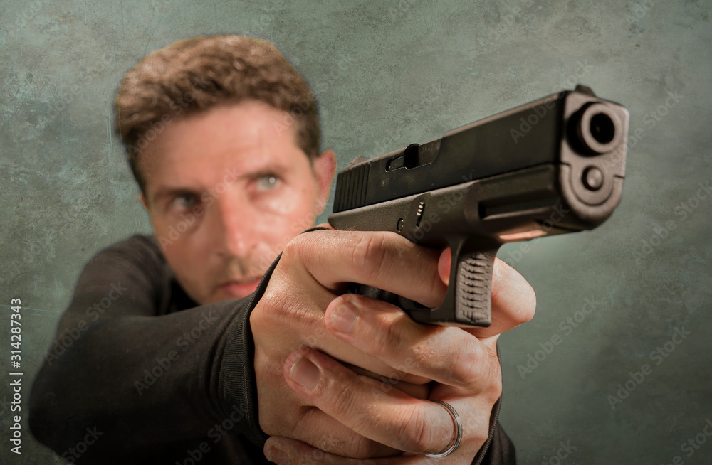 grunge cinematic portrait of attractive and dangerous looking hitman or secret service especial agent man in action pointing gun in crime mob and criminal lifestyle concept grunge cinematic portrait of attractive and dangerous looking hitman or secret service especial agent man in action pointing gun in crime mob and criminal lifestyle concept