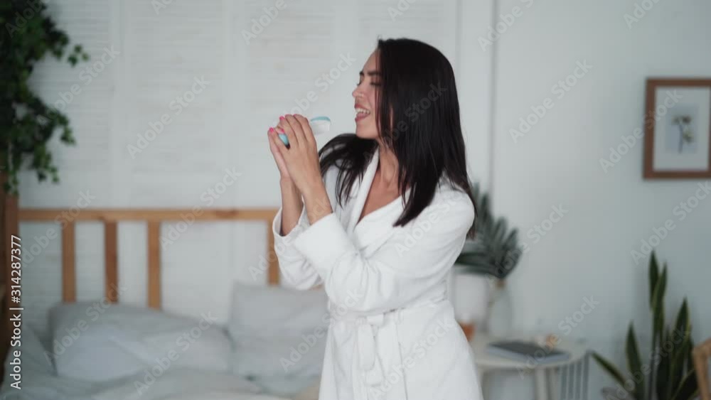 Young woman in white bathrobe dances, sings in imaginary microphone, funny video Young woman in white bathrobe dances, sings in imaginary microphone, funny video