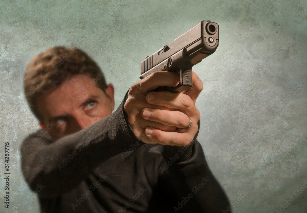 grunge cinematic portrait of attractive and dangerous looking hitman or secret service especial agent man in action pointing gun in crime mob and criminal lifestyle concept grunge cinematic portrait of attractive and dangerous looking hitman or secret service especial agent man in action pointing gun in crime mob and criminal lifestyle concept