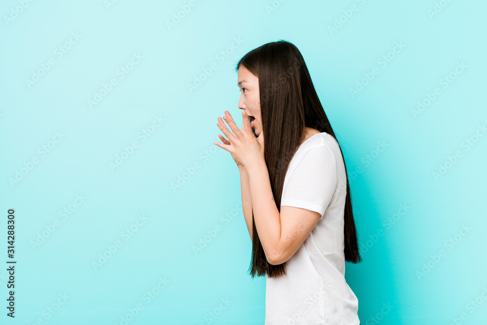 Young pretty chinese woman shouts loud, keeps eyes opened and hands tense. Young pretty chinese woman shouts loud, keeps eyes opened and hands tense.