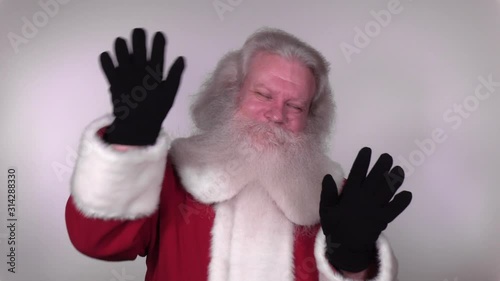 Senior Caucasian smiling man in Santa Claus suit with splendid grey hair, mustache and beard is greeting. Funny portrait of handsome European merry people on white background close up.
