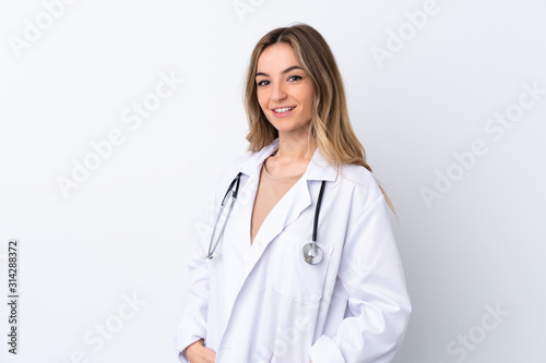 Young woman over isolated white background wearing a doctor gown and with stethoscope
