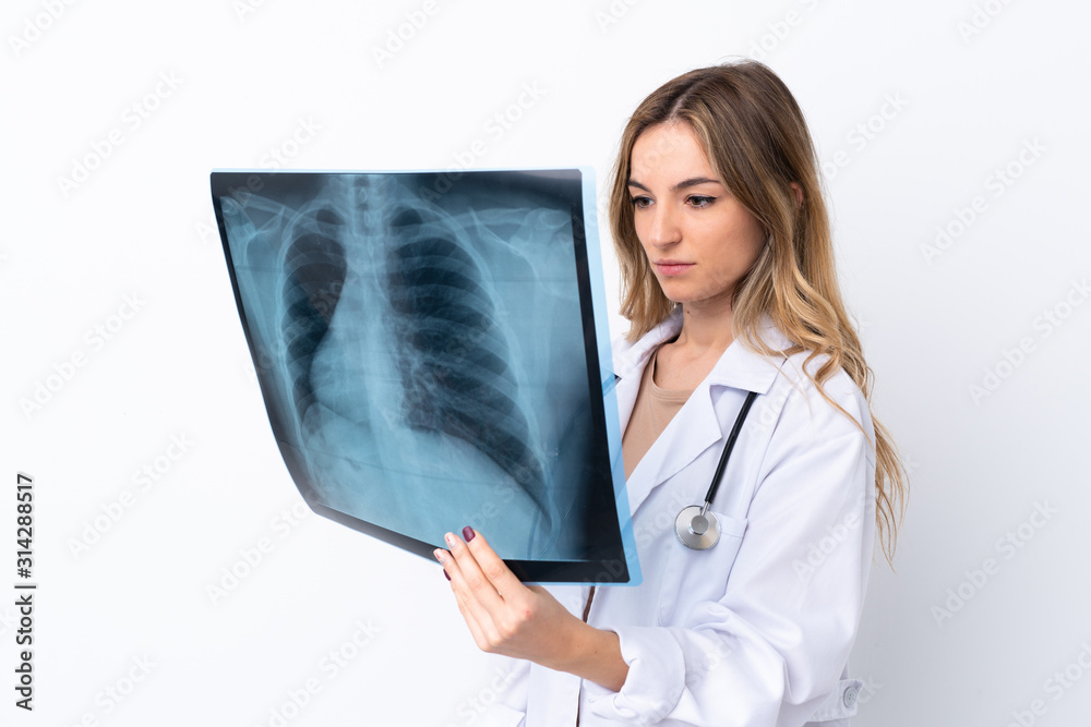 Young woman over isolated white background wearing a doctor gown and holding a bone scan Young woman over isolated white background wearing a doctor gown and holding a bone scan