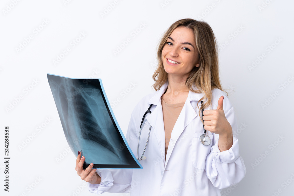 Young woman over isolated white background wearing a doctor gown and holding a bone scan Young woman over isolated white background wearing a doctor gown and holding a bone scan