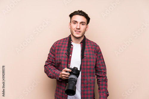 Young caucasian photographer man isolated happy, smiling and cheerful.