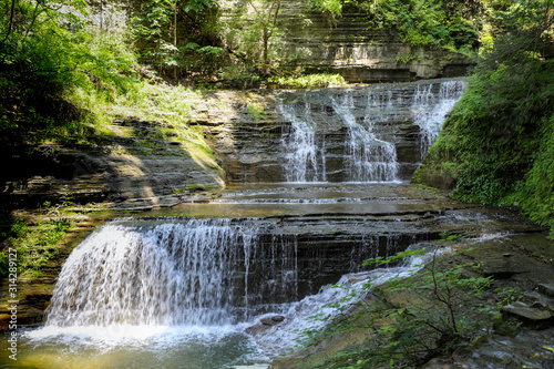 Waterfalls at Buttermilk Falls State Park. Double falls with morning sun on the pool at the bottom