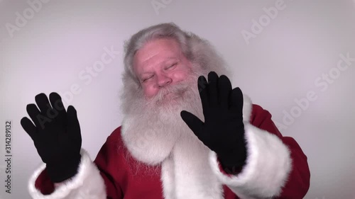 Senior Caucasian smiling man in Santa Claus suit with splendid grey hair, moustache and beard is dancing. Funny portrait of handsome European merry people on white background close up.