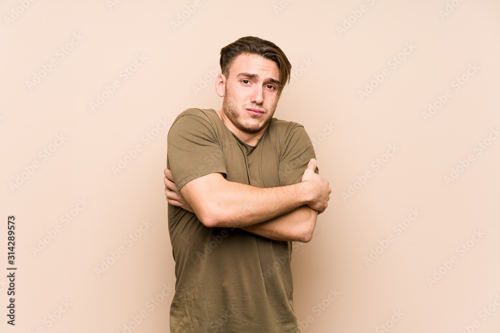 Young caucasian man posing isolated going cold due to low temperature or a sickness. Young caucasian man posing isolated going cold due to low temperature or a sickness.