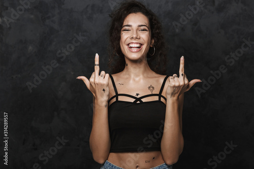 Konstfotografi Image of young joyful woman smiling and showing middle fingers