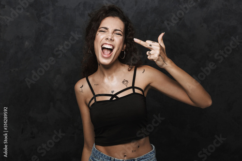 Photos Image of young excited woman smiling and showing middle finger