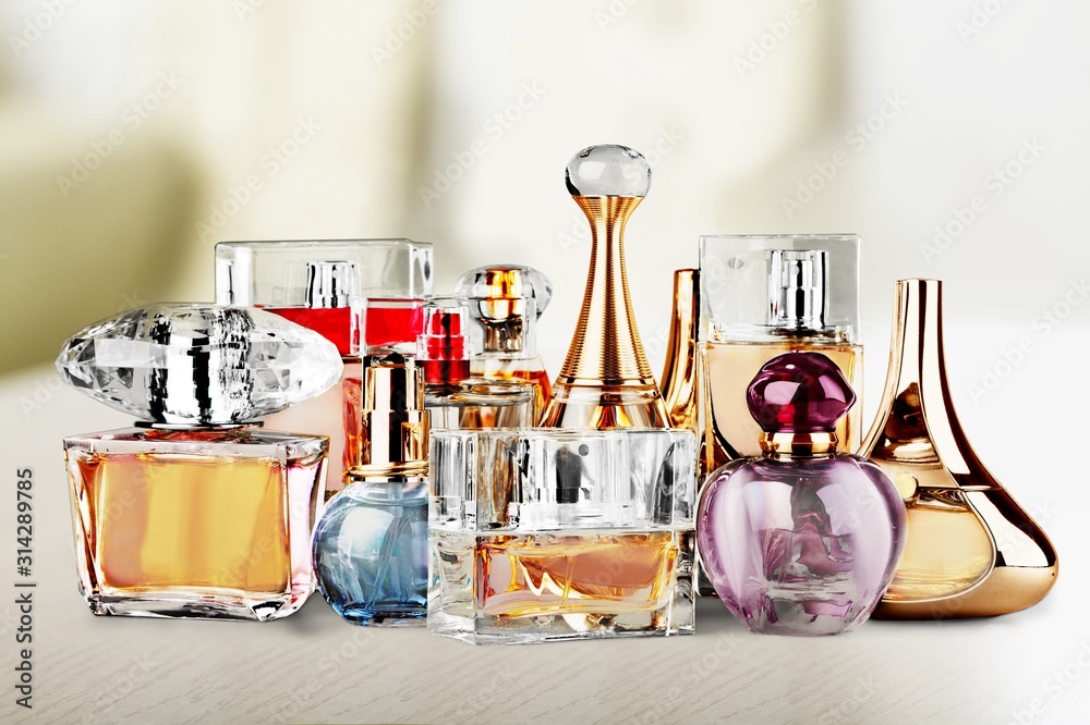 Aromatic Perfume bottles on white wooden desk at wooden background - obrazy, fototapety, plakaty 