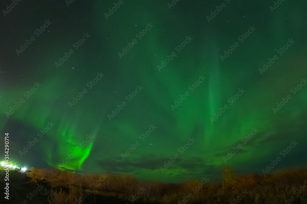 Aurora borealis in night northern sky. Ionization of air particl