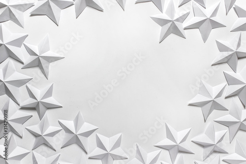 Fototapeta Naklejka Na Ścianę i Meble -  Circular arrangement of folded origami stars on white background. Photo with copy blank space.