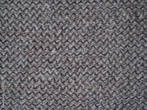 Knitted fabric texture. Gray. Simple knitting with front and back loops. Knitting on the knitting needles. Horizontal lines.