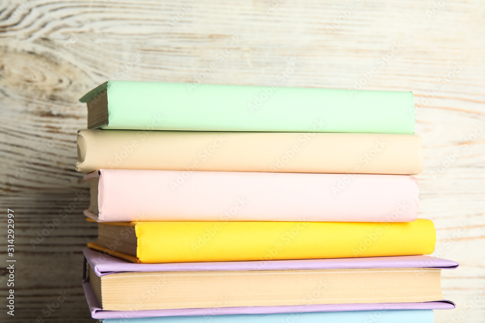 Stack of colorful books on white wooden background Stack of colorful books on white wooden background