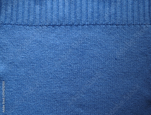 Knitted fabric texture. Blue. Garter stitch with facial loops. Knitting on the knitting needles. Knitted background.