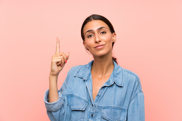 Young woman over isolated pink background pointing with the index finger a great idea