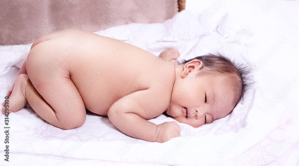 The newborn baby sleeping on white soft cloth,happy feeling on background The newborn baby sleeping on white soft cloth,happy feeling on background
