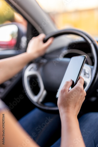 Woman driving a car and using a phone