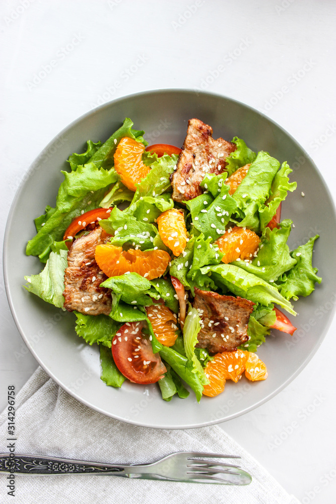 Salad with sweet tangerines and pieces of pork Salad with sweet tangerines and pieces of pork