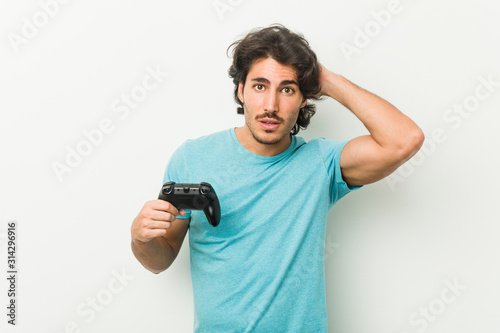 Young man holding a game controller being shocked, she has remembered important meeting.