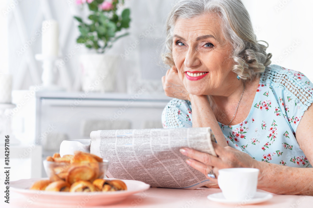 Portrait of thoughtful aged woman reading newspaper Portrait of thoughtful aged woman reading newspaper