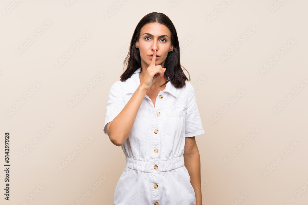 Young woman over isolated background showing a sign of silence gesture putting finger in mouth