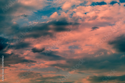 Background from Dark Thunderstorm Sky with clouds at sunset. Sun rays light clouds on top with red and orange colors. © Naletova