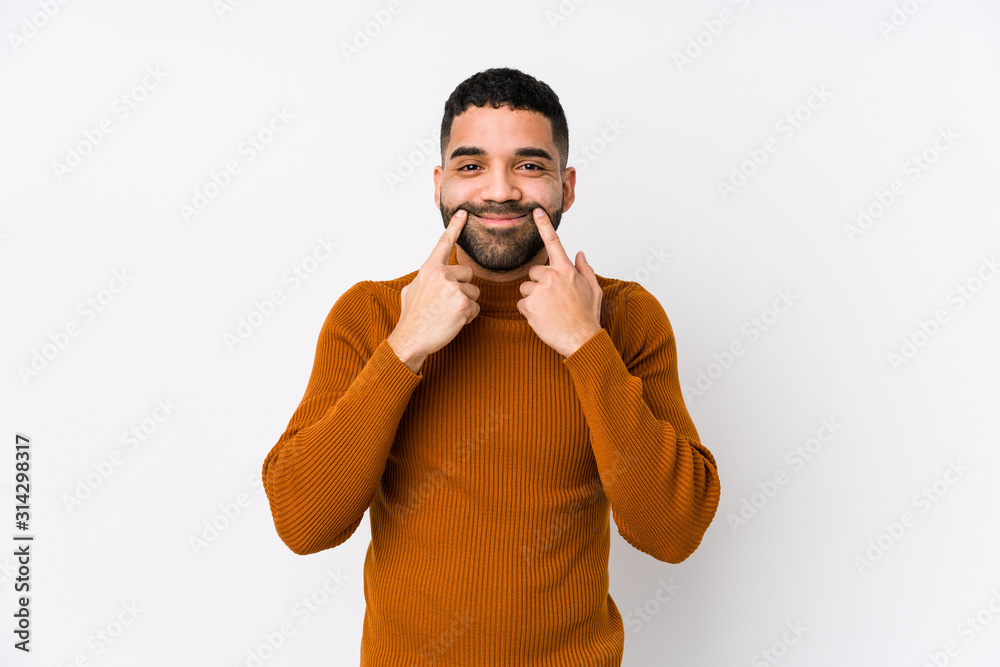 Young latin man against a white background isolated doubting between two options. Young latin man against a white background isolated doubting between two options.