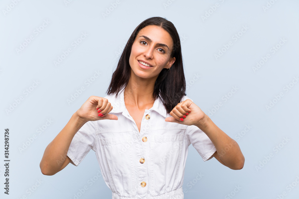 Young woman over isolated blue background proud and self-satisfied Young woman over isolated blue background proud and self-satisfied