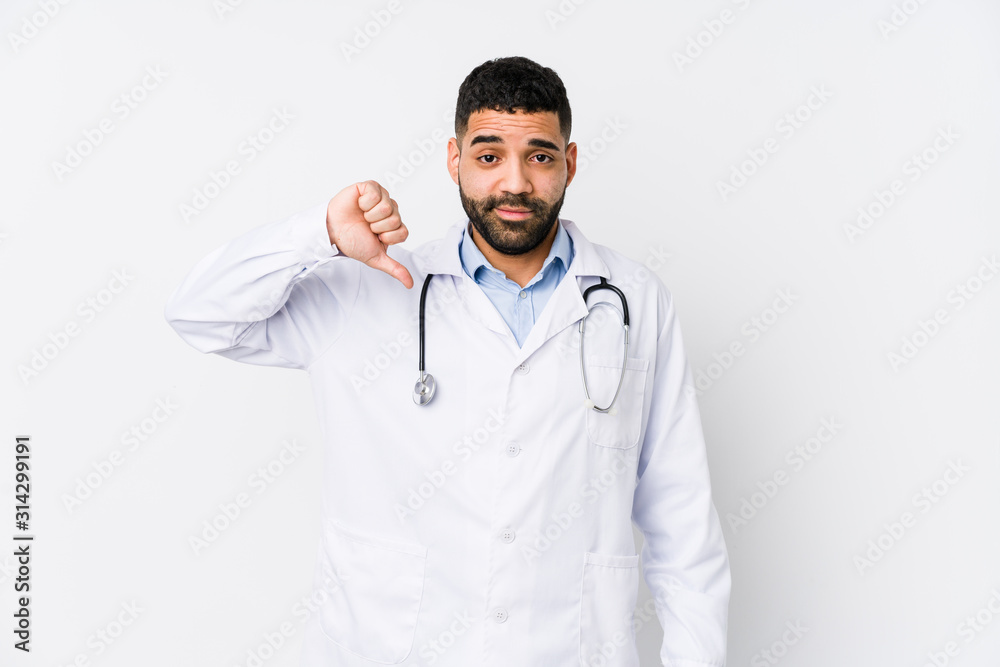 Fototapeta premium Young arabian doctor man isolated showing a dislike gesture, thumbs down. Disagreement concept.