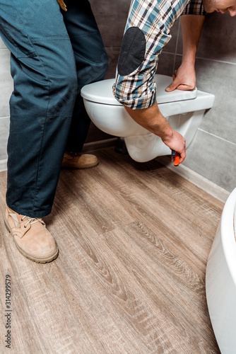 cropped view of man installing white toilet