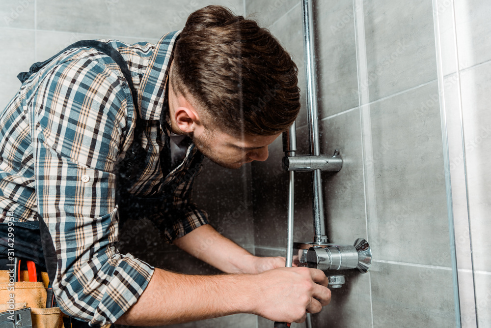 installer touching metallic pipe in bathroom installer touching metallic pipe in bathroom